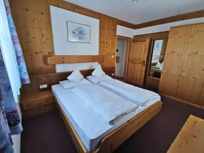 a bedroom with a large bed with wooden walls at Rastenfeldhof in Parcines