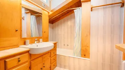 a bathroom with a sink and a mirror and a tub at Appartamenti Pagan in San Vito di Cadore