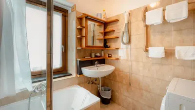 a bathroom with a sink and a bath tub at Appartamenti Pagan in San Vito di Cadore