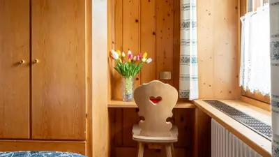 a small room with a vase of flowers on a shelf at Appartamenti Pagan in San Vito di Cadore