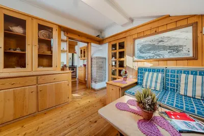 a living room with a blue couch and wooden cabinets at Appartamenti Pagan in San Vito di Cadore