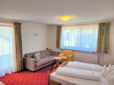 a living room with two beds and a couch at Hotel Tonnerhof in Racines