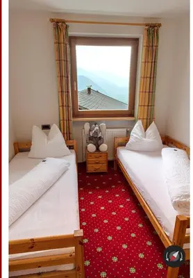 two beds in a room with a window at Hotel Tonnerhof in Racines