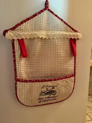 a bag hanging on a wall with red handles at Appartamento Al Laghetto in San Martino di Castrozza