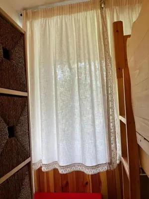 a curtain on a window in a bedroom at Appartamento Al Laghetto in San Martino di Castrozza