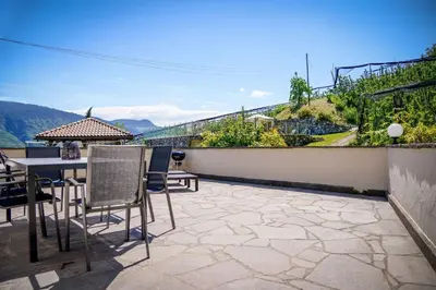 a patio with a table and chairs on a balcony at Appartements Kirchtalhof in Lana