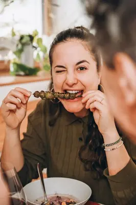 a woman is eating food in front of a bowl of food at Wolter Landhaus in Vipiteno