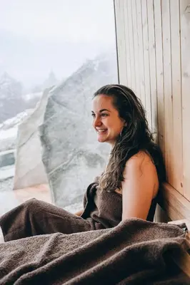 a woman sitting on a window sill smiling at Wolter Landhaus in Vipiteno