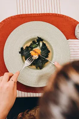 a person holding a fork and a plate of food at Wolter Landhaus in Vipiteno
