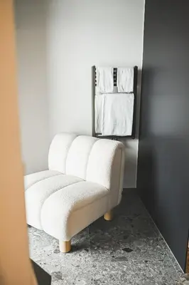 a white chair in a room with towels at Wolter Landhaus in Vipiteno
