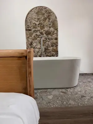 a bath tub in a room with a stone wall at Wolter Landhaus in Vipiteno