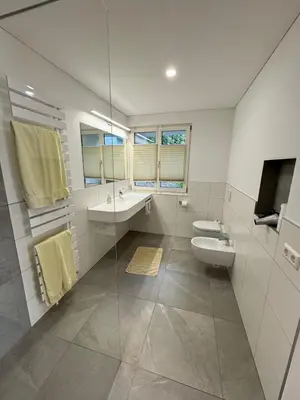 a white bathroom with a sink and a toilet at Lindenhof Residence Meran in Merano