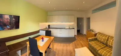 a kitchen and living room with a couch and a table at Lindenhof Residence Meran in Merano