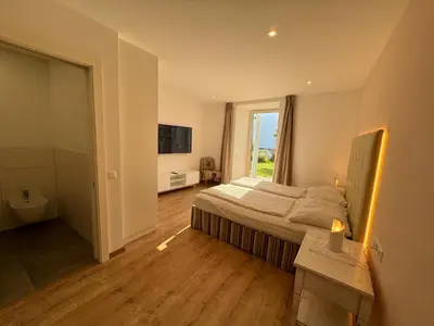 a bedroom with a bed and a large window at Lindenhof Residence Meran in Merano