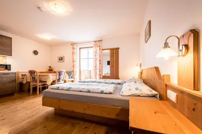 a bedroom with a bed and a dining room at Oberbaumgartnerhof in Falzes