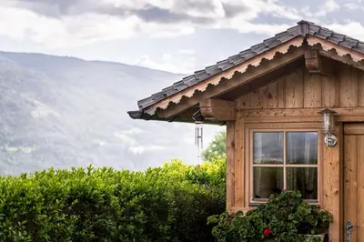 a cabin with a window and a mountain in the background at Oberbaumgartnerhof in Falzes