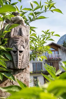 a wooden carving of a head on a post at Agritur Artemisia in Tesero