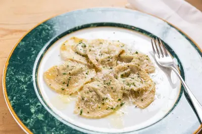 a plate of pasta with a fork on a table at Gasthof zur Krone in Aldino