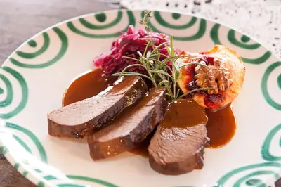 a plate of food with meat and vegetables on a table at Gasthof zur Krone in Aldino
