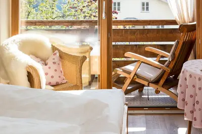 a room with a balcony with a bed and a chair at Gasthof zur Krone in Aldino