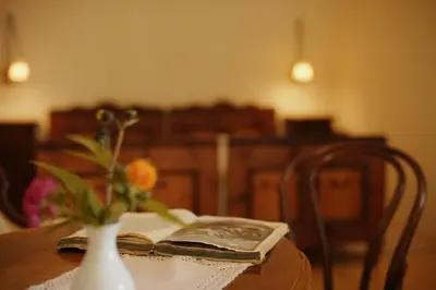 a table with a book and a vase with a flower at Gasthof zur Krone in Aldino