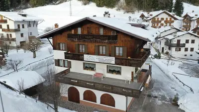 a large wooden building with balconies on top of it at Garnì Valdan in Falcade