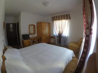a bedroom with a bed with a red pillow on it at Garnì Valdan in Falcade