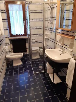 a bedroom with a large white bed in a room at Garnì Valdan in Falcade