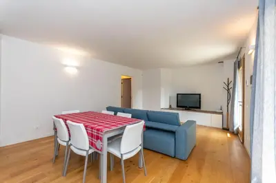 a living room with a table and a blue couch at La Casa di Sofia in Alleghe
