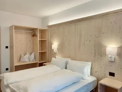 a bedroom with a bed with white sheets and pillows at Cesa Do Ruf eurochalet in Campitello di Fassa