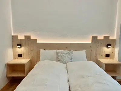 a bedroom with a large bed with two side tables at Cesa Do Ruf eurochalet in Campitello di Fassa
