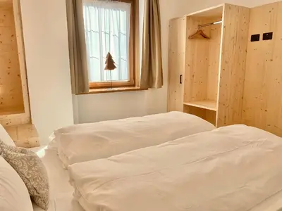 two white beds in a room with a window at Cesa Do Ruf eurochalet in Campitello di Fassa