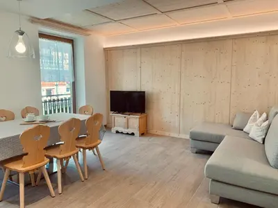 a living room with a table and a couch at Cesa Do Ruf eurochalet in Campitello di Fassa