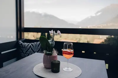 a glass of wine on a table with a view at Hotel Schönbrunn in Schenna