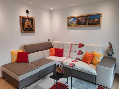 a living room with a couch and a table at appartamento PANORAMA in Pozza di Fassa