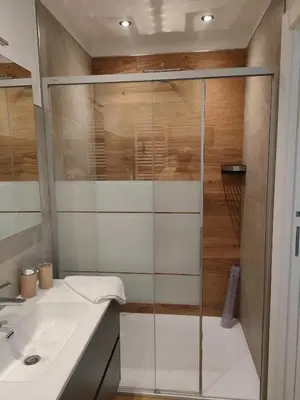 a bathroom with a glass shower and a sink at appartamento PANORAMA in Pozza di Fassa