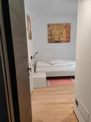 a small bedroom with a bed and a painting on the wall at appartamento PANORAMA in Pozza di Fassa