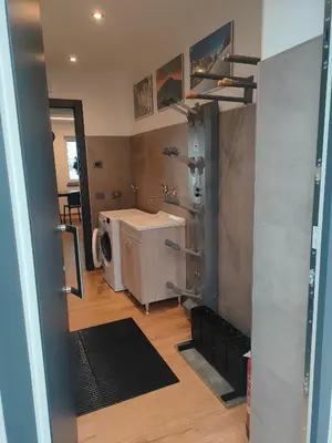 a bathroom with a sink and a washing machine at appartamento PANORAMA in Pozza di Fassa
