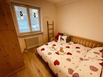 a bedroom with a bed with two teddy bears on it at Cuore delle Dolomiti - Alpine Stay Apartments in Ziano di Fiemme