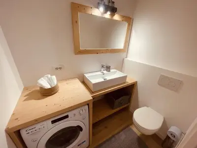 a bathroom with a washing machine and a sink at Cuore delle Dolomiti - Alpine Stay Apartments in Ziano di Fiemme