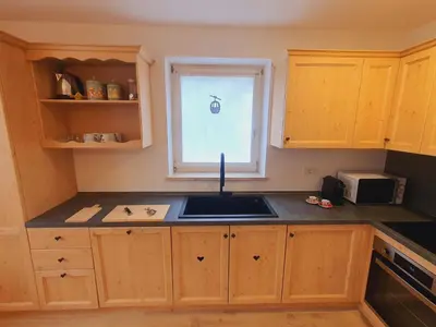 a kitchen with a sink and a window at Cuore delle Dolomiti - Alpine Stay Apartments in Ziano di Fiemme
