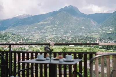 a table on a balcony with a view of mountains at Ferienappartement Freiblick in Marlengo