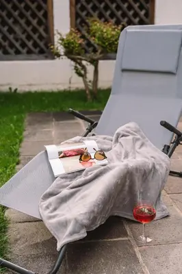 a chair with a blanket and a glass of wine at Ferienappartement Freiblick in Marlengo