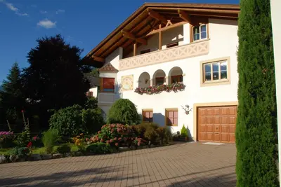 a large white house with a driveway at Ferienwohnungen Günzelgut in Lana
