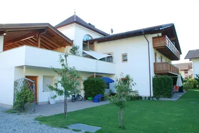 a white house with trees in the yard at Ferienwohnungen Günzelgut in Lana