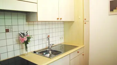 a kitchen with a sink and a vase of flowers at Ferienwohnungen Günzelgut in Lana