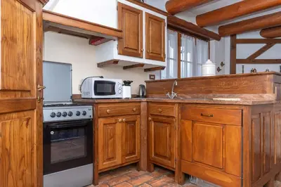 a kitchen with wooden cabinets and a microwave at Tabia Maredane in Falcade