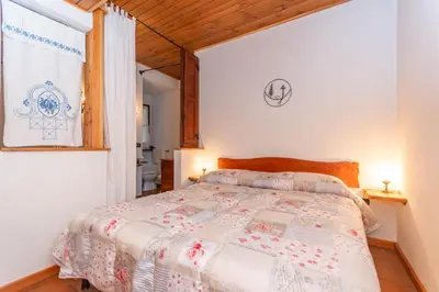 a bedroom with a bed in a room with a window at Tabia Maredane in Falcade