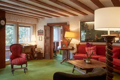 a living room with a red couch and a table at Lioda Castle in Cortina dʼAmpezzo