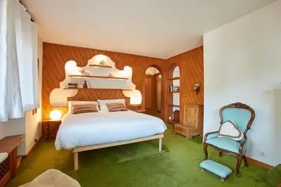 a bedroom with a white bed and a chair at Lioda Castle in Cortina dʼAmpezzo